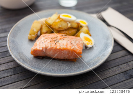 Steamed salmon fillet with potato wedges and quail egg Steamed salmon fillet with potato wedges and quail egg 123258476