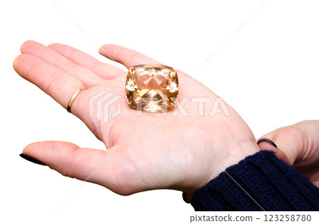 Woman hand holding natural brown zircon mineral, isolated on white background 123258780