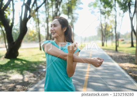 Beautiful young woman stretching arms before outdoor workout Beautiful young woman stretching arms before outdoor workout 123259280