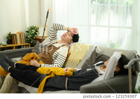 Exhausted young couple resting on the sofa after house cleaning 123259307