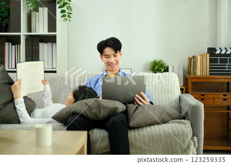 Relaxed young couple lounging on a cozy couch during leisure weekend time Relaxed young couple lounging on a cozy couch during leisure weekend time 123259335