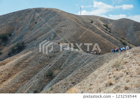 tourists travelers climbing the path to the mountain on a hike tourists travelers climbing the path to the mountain on a hike 123259544