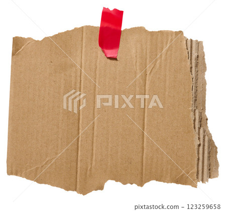 Torn piece of brown corrugated cardboard attached to red piece of electrical tape, isolated background 123259658