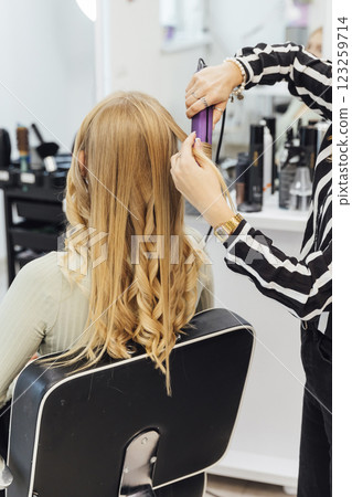 Hairstyle master stylist doing styling for a woman in a hairdresser 123259714