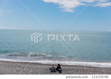 Man And Woman Sitting On Beach And Looking At Sea 123259796