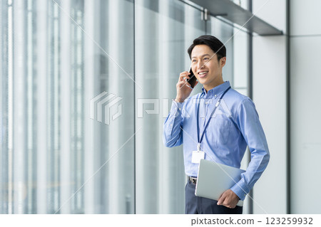 A middle-aged engineer making a phone call in the office. Photo courtesy of Sky Perfect Tokyo Media Center. 123259932