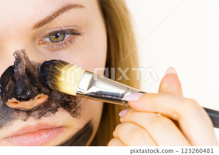 Girl being apply black mask to skin face 123260481