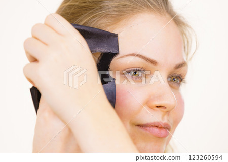 Girl removes black mask from face Girl removes black mask from face 123260594