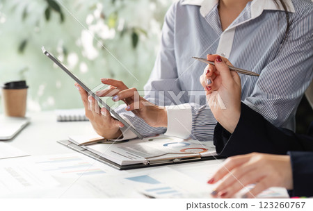 Professional team analyzing financial reports and data in a modern office setting, discussing strategies and insights. Professional team analyzing financial reports and data in a modern office setting, discussing strategies and insights. 123260767