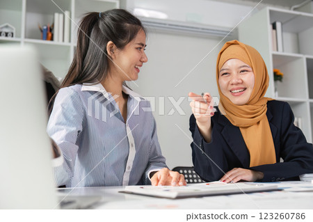 Diverse financial experts sharing insights in a modern office environment. Diverse financial experts sharing insights in a modern office environment. 123260786