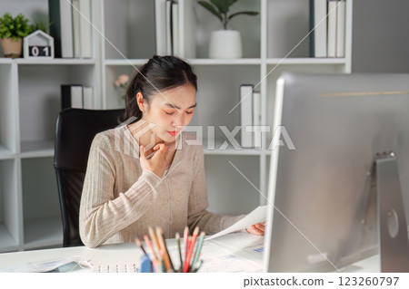 Office worker feeling unwell while reviewing documents at her desk. Office worker feeling unwell while reviewing documents at her desk. 123260797