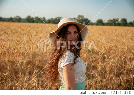 Young woman in sun hat enjoying summer in wheat field. Harvesting concept Young woman in sun hat enjoying summer in wheat field. Harvesting concept 123261338