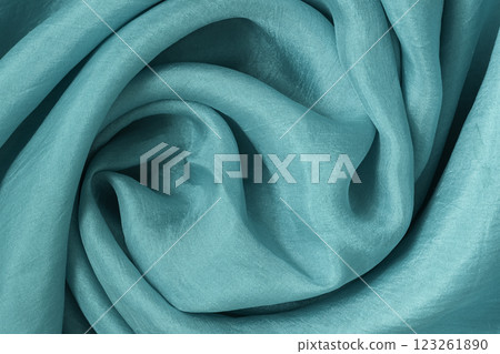 Close-up of turquoise silk fabric with soft folds and flowing texture Close-up of turquoise silk fabric with soft folds and flowing texture 123261890