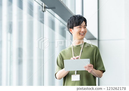 辦公室裡一位年輕的工程師拿著平板電腦。 123262178