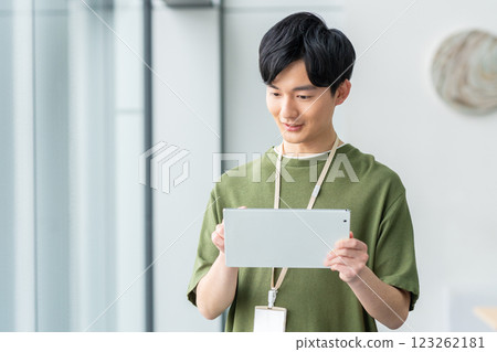 A young engineer holding a tablet in an office. Photo courtesy of Sky Perfect TV Tokyo Media Center. 123262181