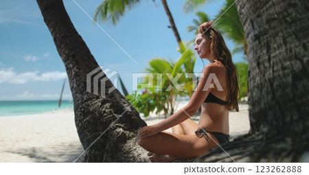 Woman enjoy sandy beach sitting coconut palm tree looking at crystal blue ocean water. Slim tourist girl at vacation holiday relax travel journey. White Beach, Boracay Island, Philippines. Slow Woman enjoy sandy beach sitting coconut palm tree looking at crystal blue ocean water. Slim tourist girl at vacation holiday relax travel journey. White Beach, Boracay Island, Philippines. Slow 123262888
