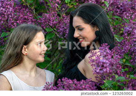 Two women in a lilac garden. Shallow depth of feld Two women in a lilac garden. Shallow depth of feld 123263002