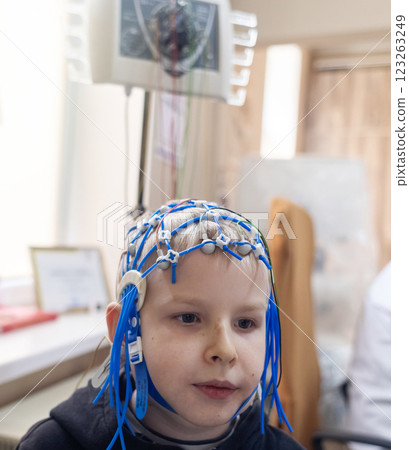A boy's brain is examined on an EEG machine. Electroencephalogram is performed in a hospital laboratory to detect neurological diseases. Encephalogram for children 123263249