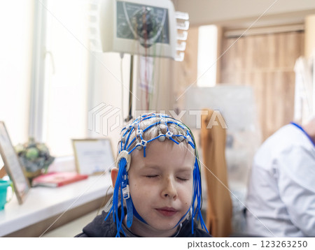 A boy's brain is examined on an EEG machine. Electroencephalogram is performed in a hospital laboratory to detect neurological diseases. Encephalogram for children 123263250