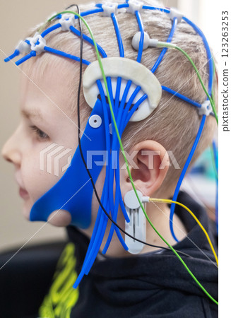 A boy's brain is examined on an EEG machine. Electroencephalogram is performed in a hospital laboratory to detect neurological diseases. Encephalogram for children 123263253