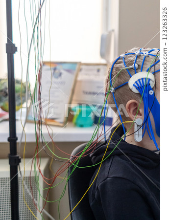 A boy's brain is examined on an EEG machine. Electroencephalogram is performed in a hospital laboratory to detect neurological diseases. Encephalogram for children A boy's brain is examined on an EEG machine. Electroencephalogram is performed in a hospital laboratory to detect neurological diseases. Encephalogram for children 123263326