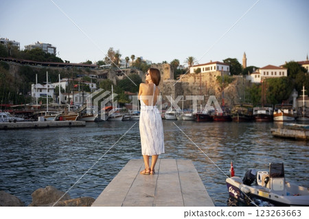 Woman admiring sunset at scenic harbor Woman admiring sunset at scenic harbor 123263663