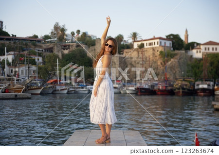 Cheerful woman posing by scenic waterfront  123263674