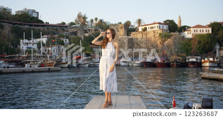 Stylish woman enjoying sunset by the harbor  123263687