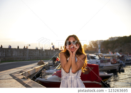 Excited woman at sunset by the harbor in Antalya old city Excited woman at sunset by the harbor in Antalya old city 123263695