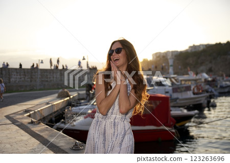 Joyful woman laughing at sunset by the harbor Joyful woman laughing at sunset by the harbor 123263696