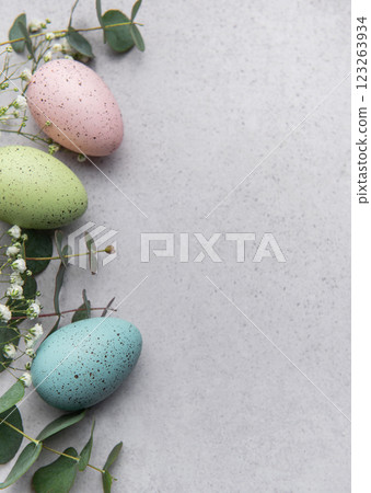 Pastel easter eggs with greenery on gray background 123263934