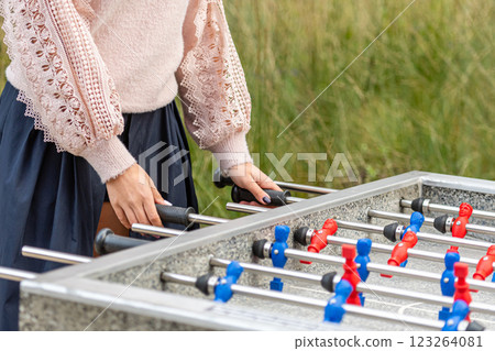 Engaging in a Friendly Outdoor Foosball Match Among Greenery on a Sunny Day 123264081