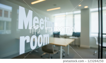 Contemporary meeting room in a modern office with glass walls, large table, and various chairs. Bright area for team collaboration, business discussions, professional gatherings, open workspace 123264250