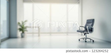 Contemporary white office with blurred background, cozy chair in focus, spacious clean workspace, minimalist design, bright lighting, modern furniture, productivity, business work 123264252