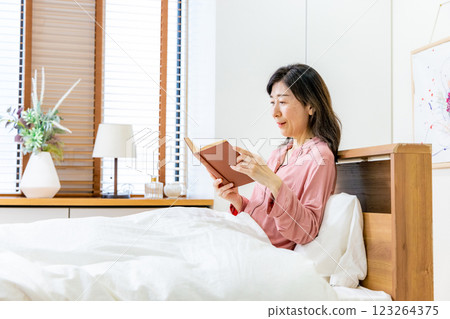 A woman reading in bed A woman reading in bed 123264375