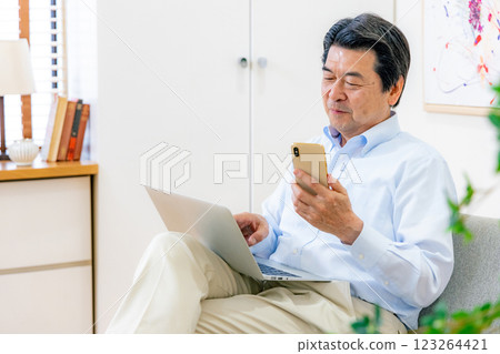 操作智慧型手機和電腦的老人 123264421