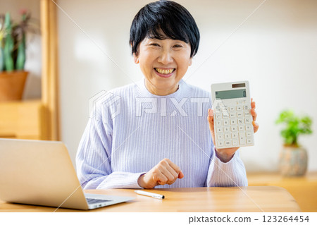 Senior woman calculating with a calculator Senior woman calculating with a calculator 123264454