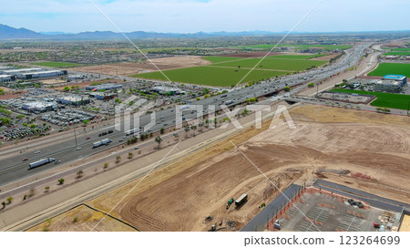 Highway traffic moves rapidly past fields, commercial properties in suburban setting on Phoenix Arizona 123264699