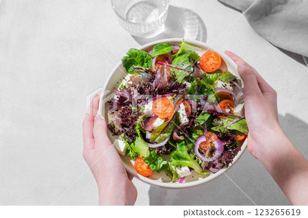 Plate of vegetable salad (Greek salad) with tomatoes, feta cheese, lettuce, olives and onions 123265619