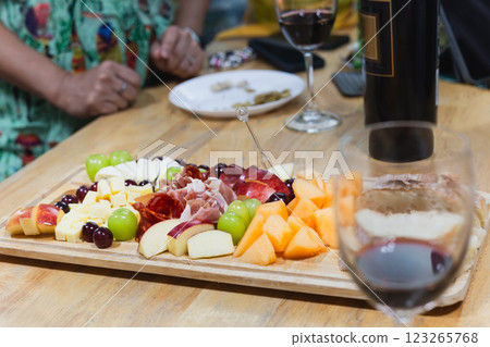 Cold cuts smoked ham and Cheese with glasses of red wine on wooden table. 123265768