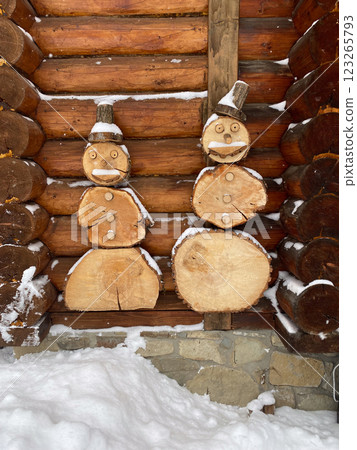 Wooden Snowmen Sculptures on Log Cabin Wall Wooden Snowmen Sculptures on Log Cabin Wall 123265793