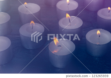 Tea light candles on a dark background, many lights in the dark 123265939
