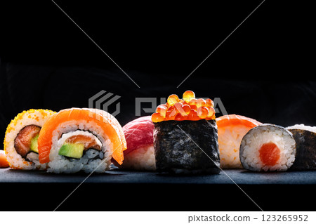 Sushi rolls on a black background. Salmon uramaki roll and ikura maki roll 123265952