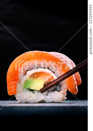 Salmon sushi with avocado and cream cheese, uramaki roll on black with copyspace Salmon sushi with avocado and cream cheese, uramaki roll on black with copyspace 123265955