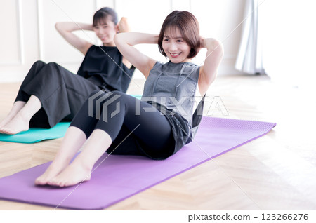 Two young women doing muscle training 123266276