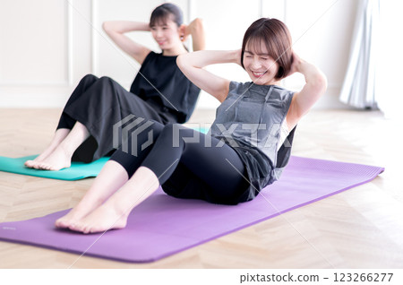 Two young women doing muscle training 123266277