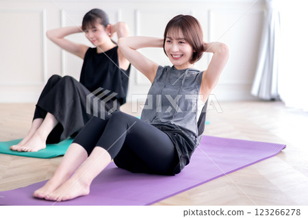 兩名年輕女子進行肌肉訓練 兩名年輕女子進行肌肉訓練 123266278