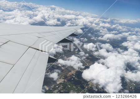 View of the plane's wing and beautiful clouds through the window during the flight. 123266426