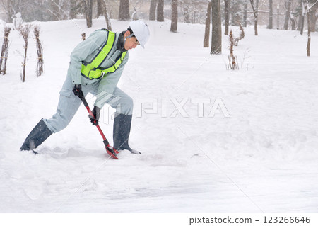 一名身穿工作服的男子正在鏟雪 123266646