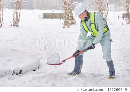 一名身穿工作服的男子正在鏟雪 123266649